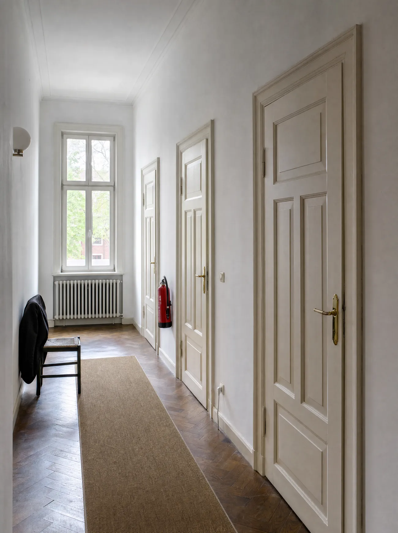 Flur mit hoher Rundbogentür in einem historischen Stadthaus.