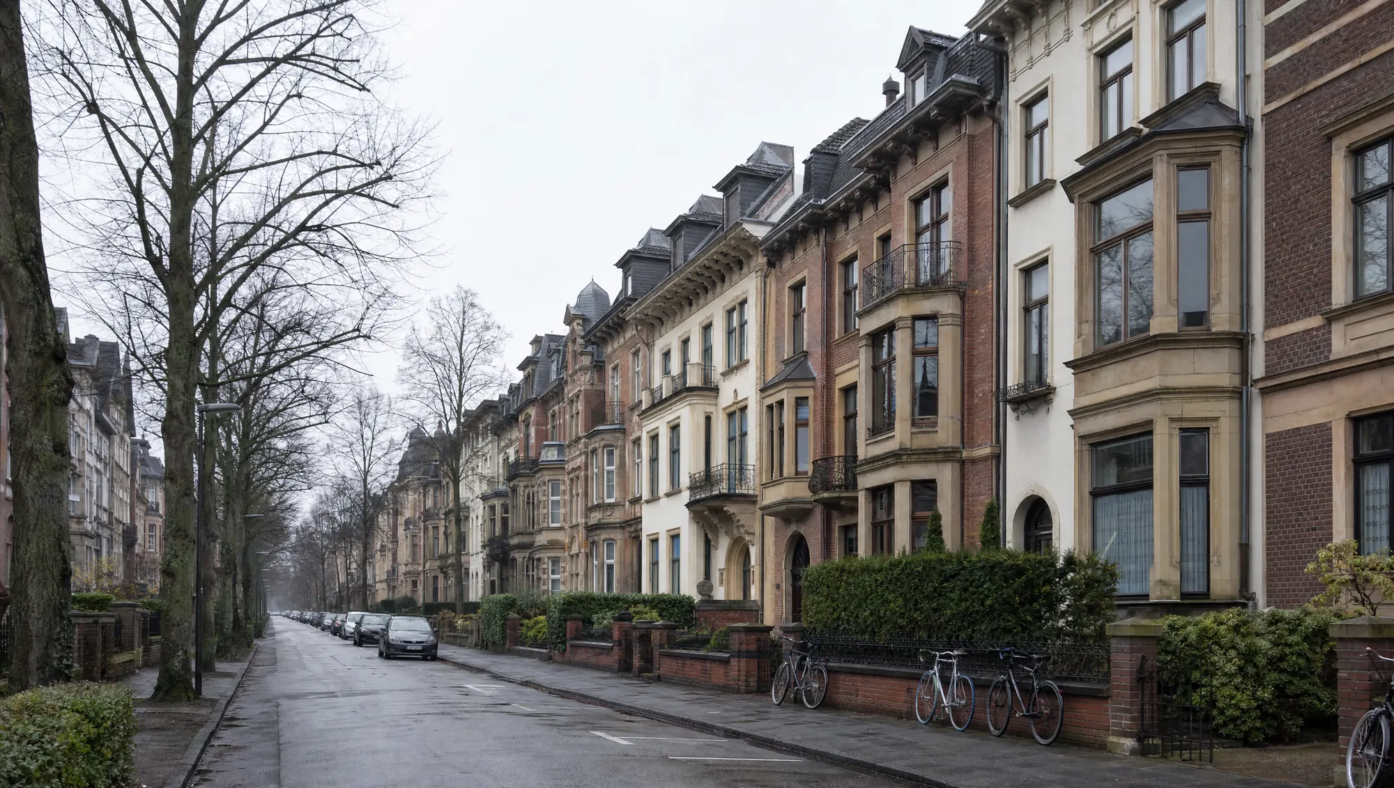 Ruhige Wohnstraße in der Innenstadt von Münster mit Backsteinhäusern, Lindenreihe und abgestellten Fahrrädern.